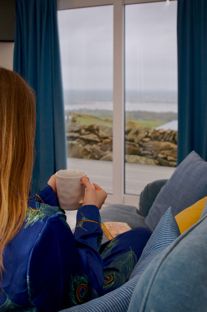 Me holding a cup of tea in one of the Seaview Snugs at Laggan